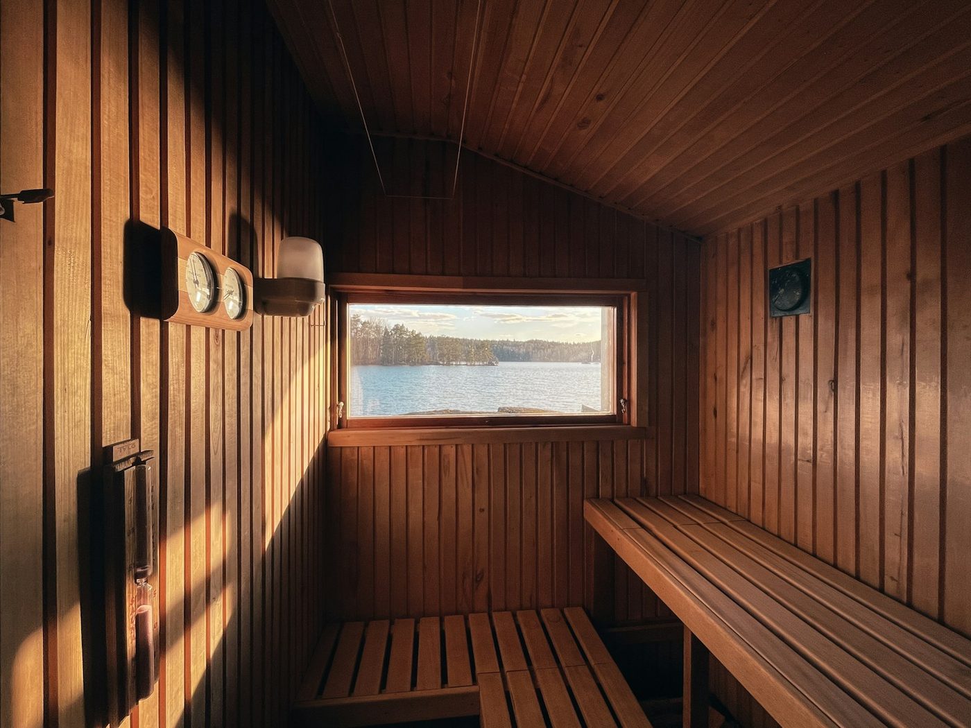 Wood sauna interior with a window over a lake