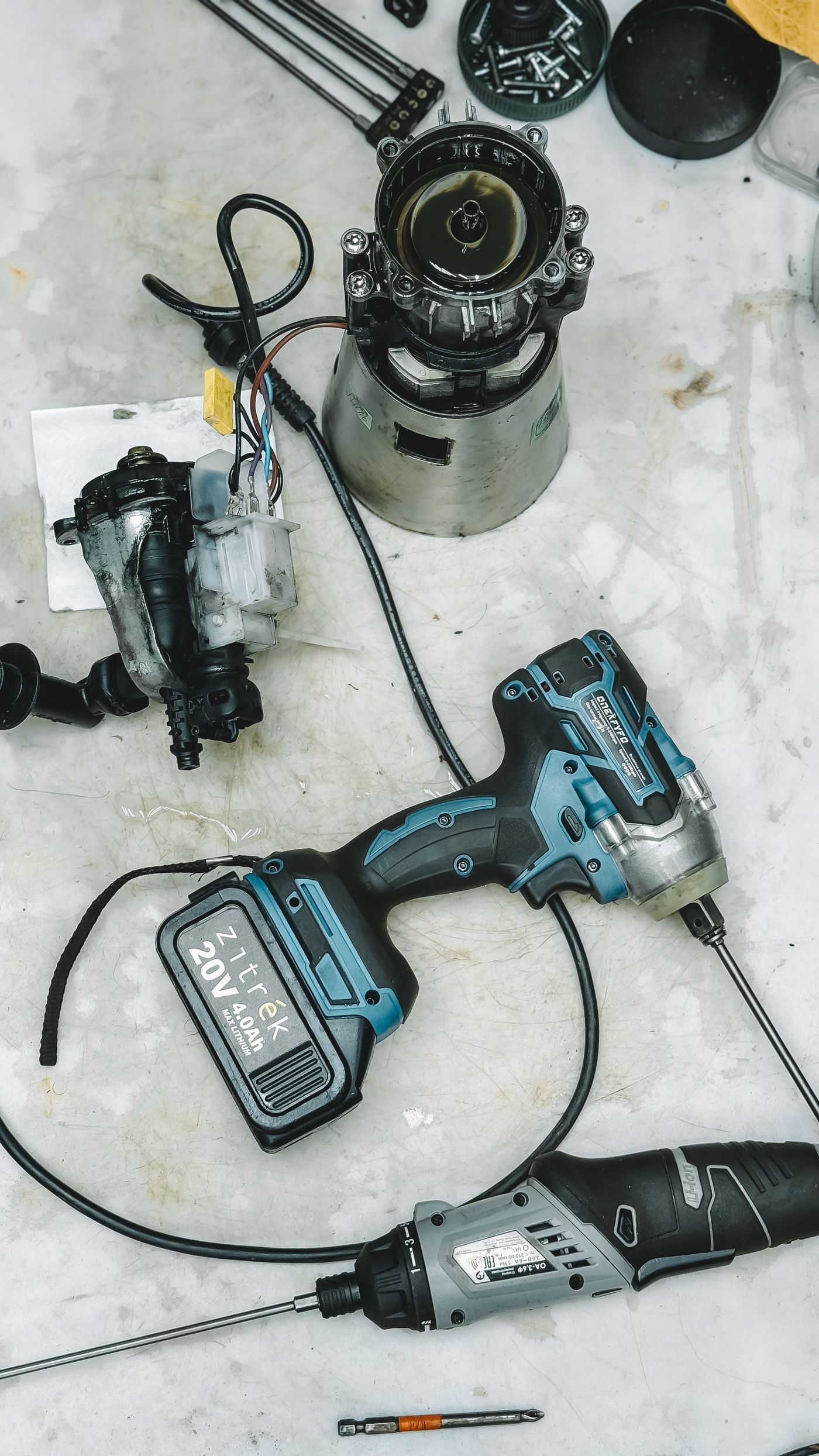 Disassembled tanning bed motor, wiring, and repair tools laid out on a service bench